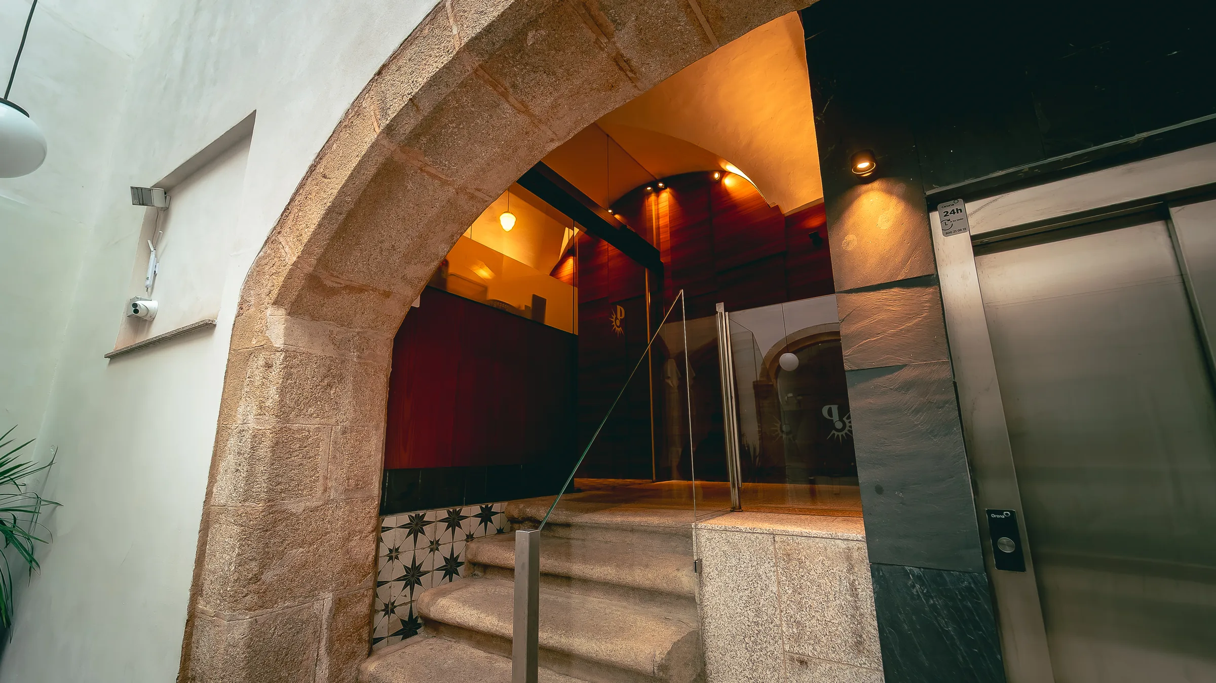 Entrada de Casa Palacchio, arco de piedra con el logo grabado en el cristal